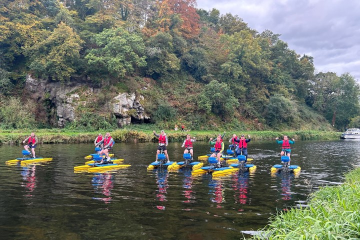 a group of people rowing a boat in the water